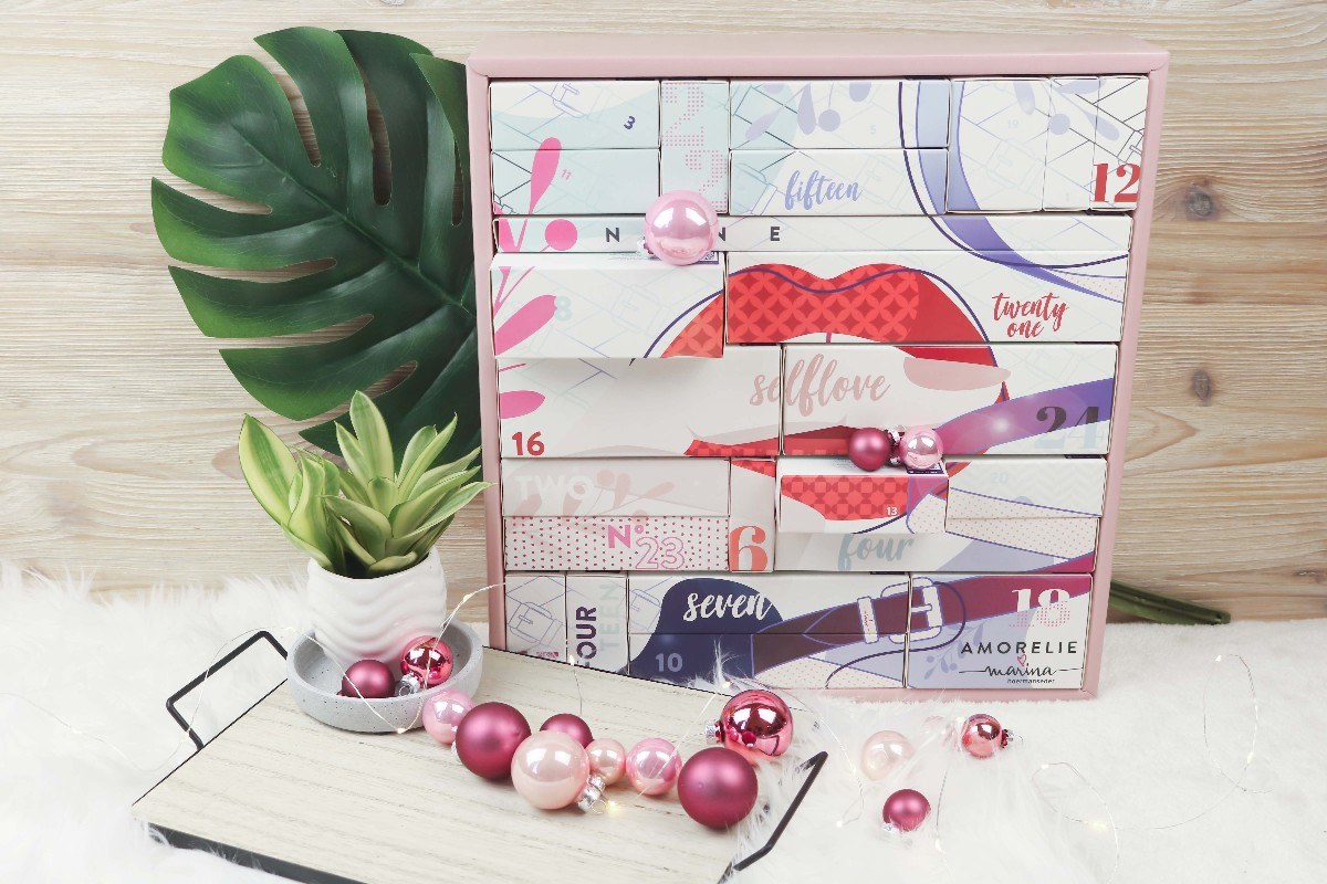 Amorelie Self Love Adventskalender in Rosa und Weiß mit Lippen-Motiv und Pflanze.